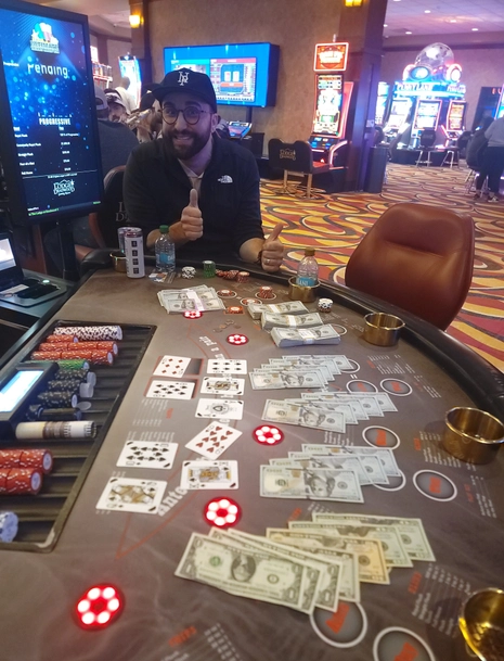 A man gives two thumbs up after winning at a table game
