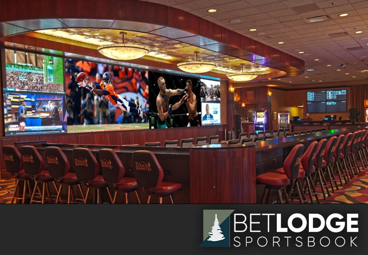 A modern sports lounge with large TV screens, cushioned seating, and a long bar for drinks. The atmosphere combines the energy of live sports with casual comfort.